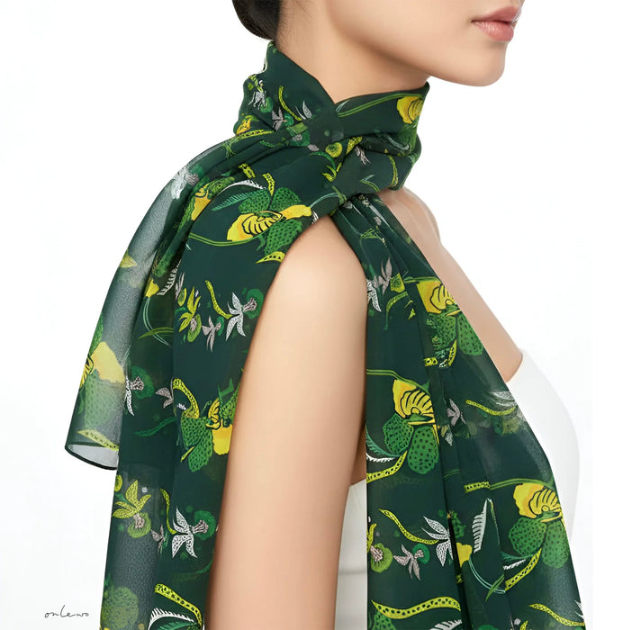 Onlewo 'Orchid Batik' silk cotton scarf detail — close-up of intricate batik-inspired orchid motifs in warm tropical tone
